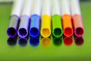 a group of colored pencils markers