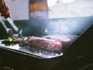 griddle raw meat on black tray