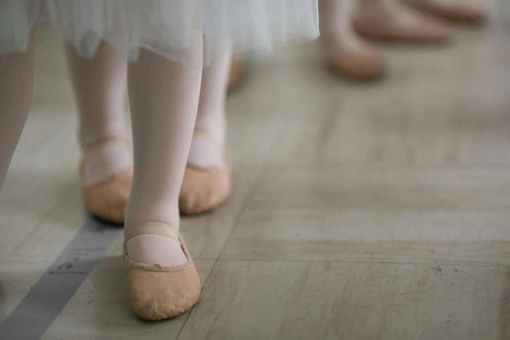 woman in white skirt and brown leather boots ballet slippers