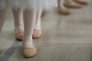 woman in white skirt and brown leather boots ballet slippers