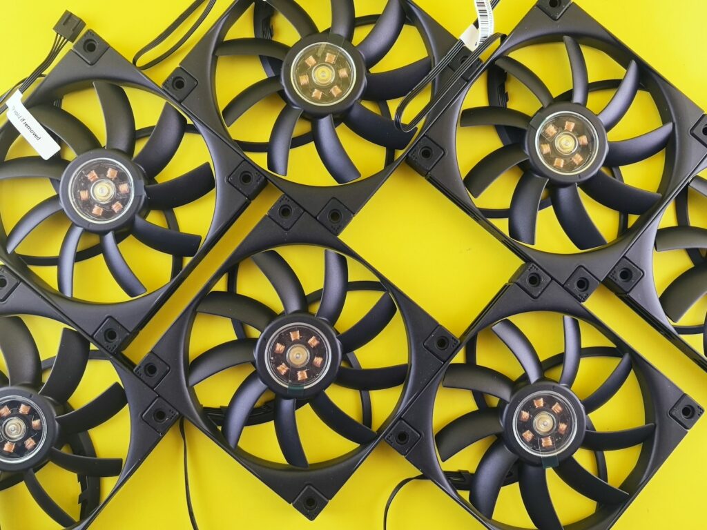 Multiple black computer fans arranged on yellow background