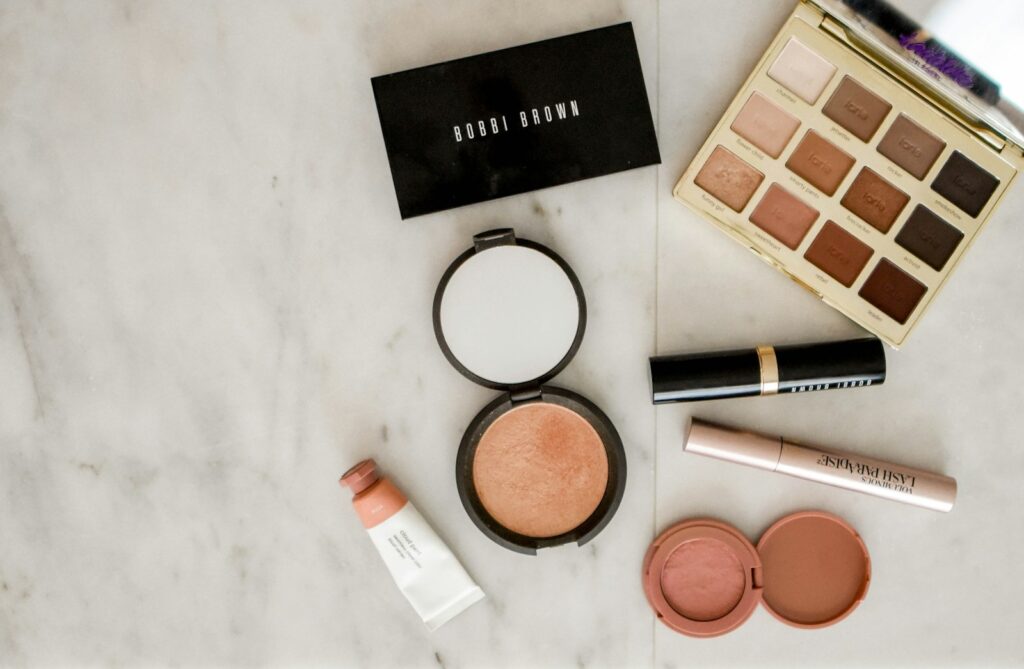 photo of assorted makeup products on gray surface make up