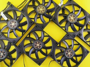 Multiple black computer fans arranged on yellow background